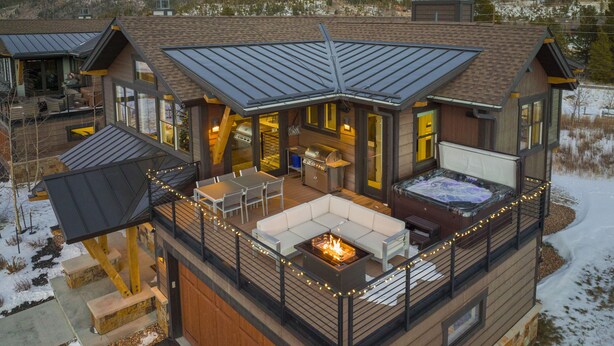A modern cabin with a deck, outdoor seating, a hot tub, and a fireplace. - Modern Elegance, Stunning Mountain Views, Hot Tub, Fire Pit, Walk to River! (Breckenridge)