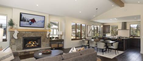 A spacious living room with a fireplace, a large TV, and a cozy seating area.