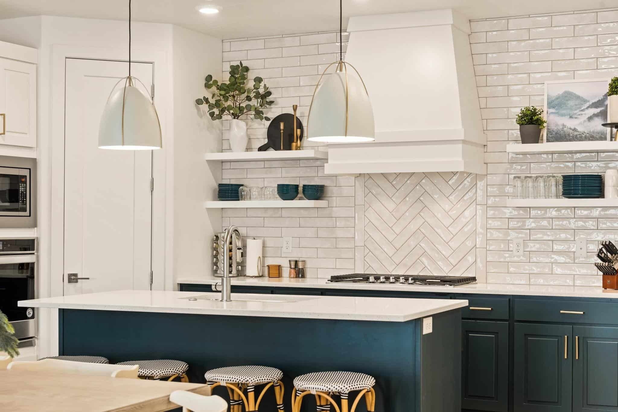 A modern kitchen with a central island, white cabinetry, and a herringbone-patterned backsplash.