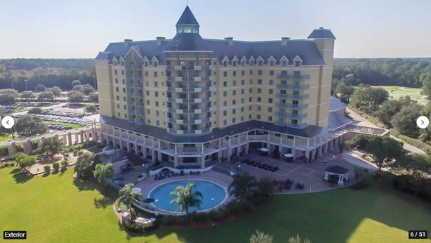 A large hotel with multiple floors, a central courtyard with a swimming pool, and a golf course in the background. - St. Augustine Villa for 6 Golf courses, tons of amenities & close to attractions (St. Augustine)