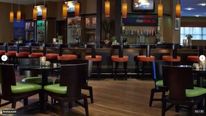 A restaurant with wooden flooring, red and green upholstered chairs, and a bar area with a minibar and bottles. - St. Augustine Villa for 6 Golf courses, tons of amenities & close to attractions (St. Augustine)