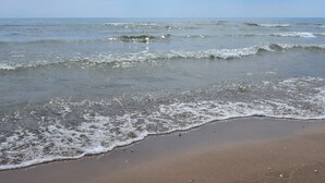 A beach with waves gently lapping onto the shore.