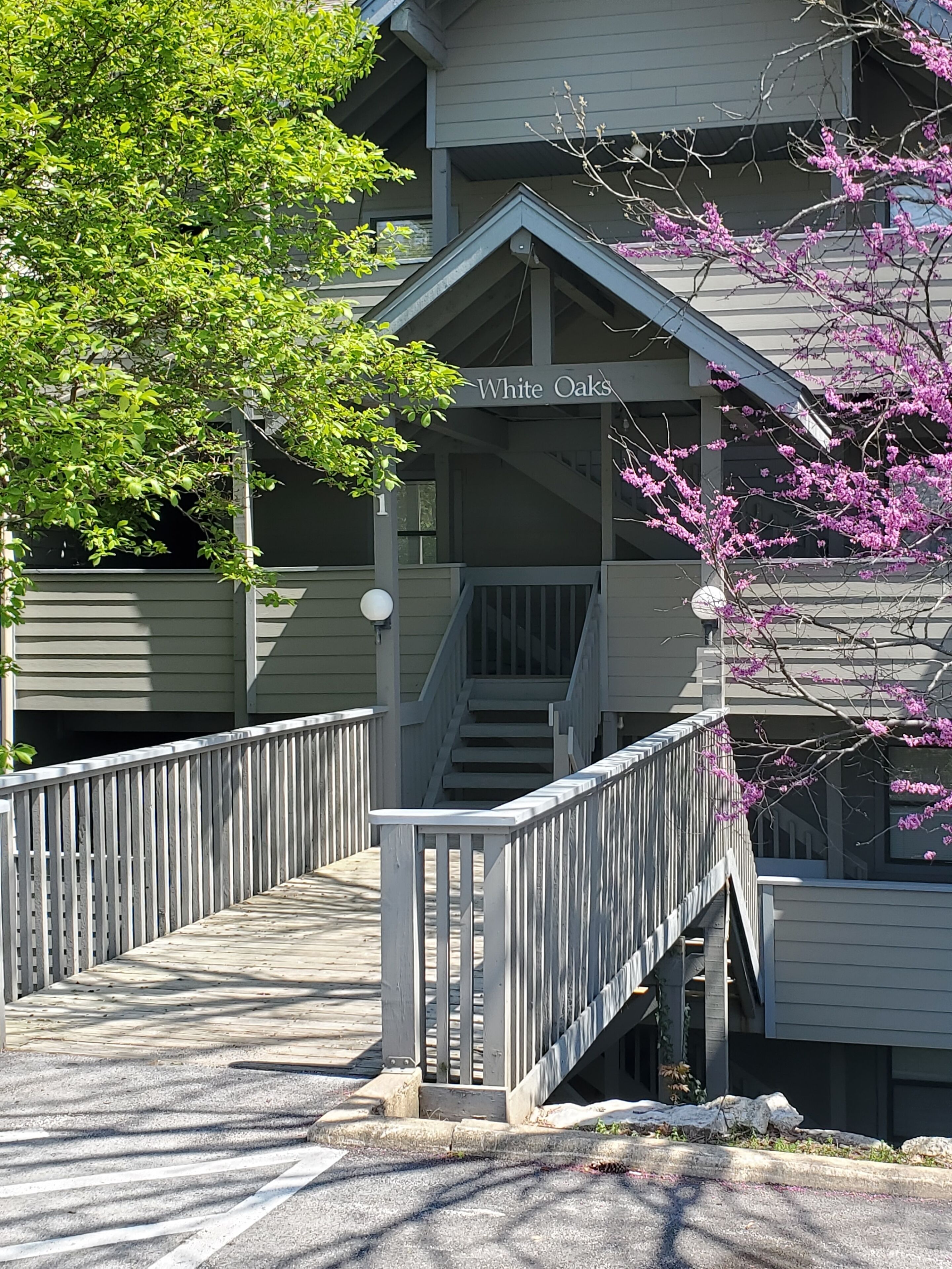 A building with a sign reading "White Oaks" and a staircase leading to an upper level.