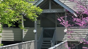 Un edificio con un letrero que dice "White Oaks" y una escalera que sube a un nivel superior.