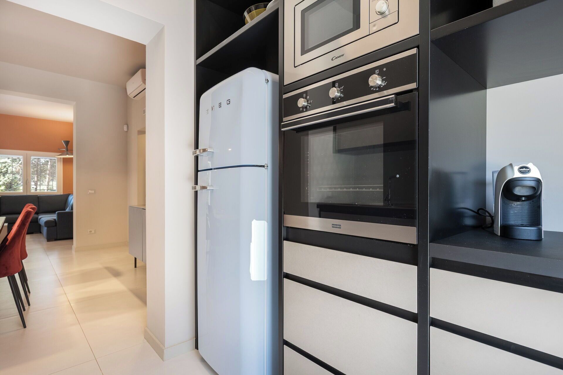 A modern kitchen with a refrigerator, oven, microwave, and coffee maker.