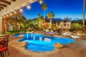 Un espace piscine comprenant un jacuzzi, des chaises longues et une terrasse en pierre.