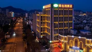 A multi-story hotel with a prominent entrance and a parking area.