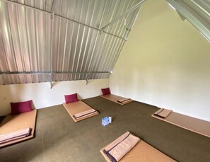 A room with four beds arranged in a square pattern, each with a pillow and a folded blanket. - Supercamp Sakura Hills (Tawangmangu)