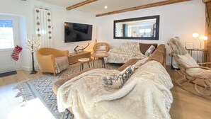 A cozy living room with a large sofa, a television, and a fireplace. - Superb Duplex 8/10 pers 5ch 3sdb 1 balcony 150M2 cocooning in the heart of Queyras (Aiguilles)