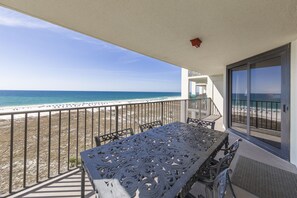 A balcony with a view of the beach and ocean.
