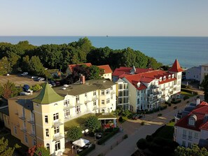 A multi-story hotel with balconies, a courtyard, and a view of the sea. - Junior suites - Hotel Residenz Waldkrone Kühlungsborn GmbH & Co.KG (Kühlungsborn)