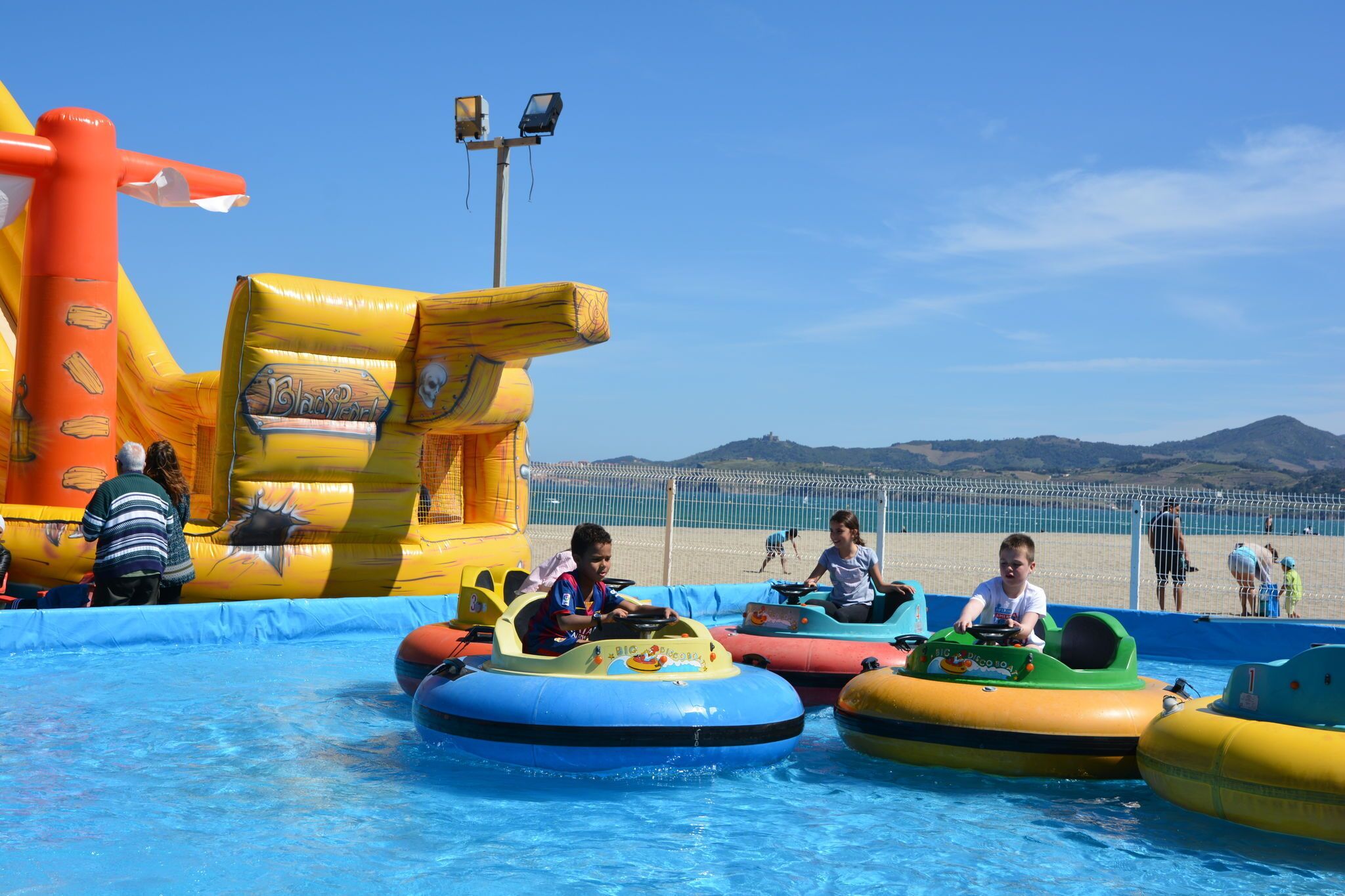 Un parc aquàtic inflable amb diverses atraccions aquàtiques i una zona de piscines.