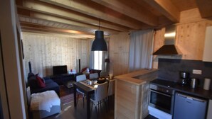 Ein kompakter Wohnraum mit Essbereich, Küchenzeile und einer Couch im Wohnzimmer.