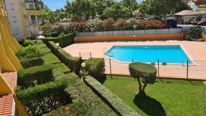 Una piscina rodeada de setos cuidados y diversas plantas en flor.