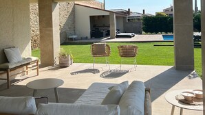 A covered outdoor seating area with a pool, stone walls, and a view of a house. - Stunning 'Finca Clos' with Mountain View, Private Pool, Garden, A/C & Wi-Fi (BORRASSA)