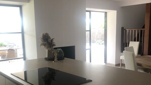 A modern kitchen with a large island, a dining area with chairs, and a view of the outdoors. - Stunning 'Finca Clos' with Mountain View, Private Pool, Garden, A/C & Wi-Fi (BORRASSA)