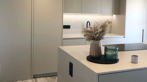 A modern kitchen with a central island, recessed ceiling lights, and a minimalist design. - Stunning 'Finca Clos' with Mountain View, Private Pool, Garden, A/C & Wi-Fi (BORRASSA)