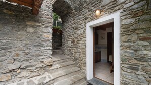 Un bâtiment en pierre avec un escalier en bois menant à une porte.