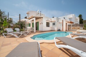 Eine moderne Villa mit Swimmingpool, Liegestühlen und einer Terrassenanlage.