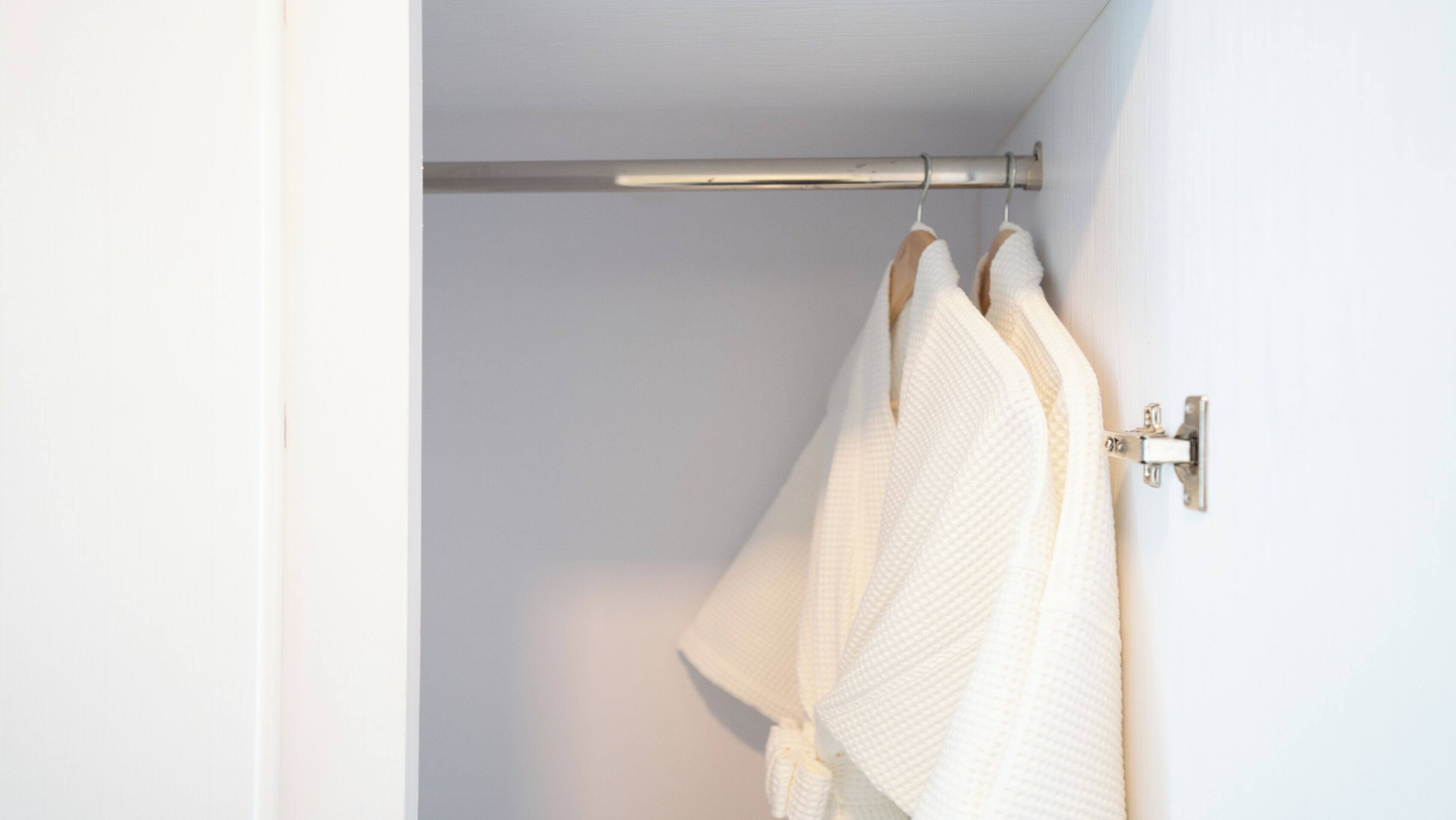 Une salle de bain avec un porte-serviettes sur lequel sont posées deux serviettes blanches.