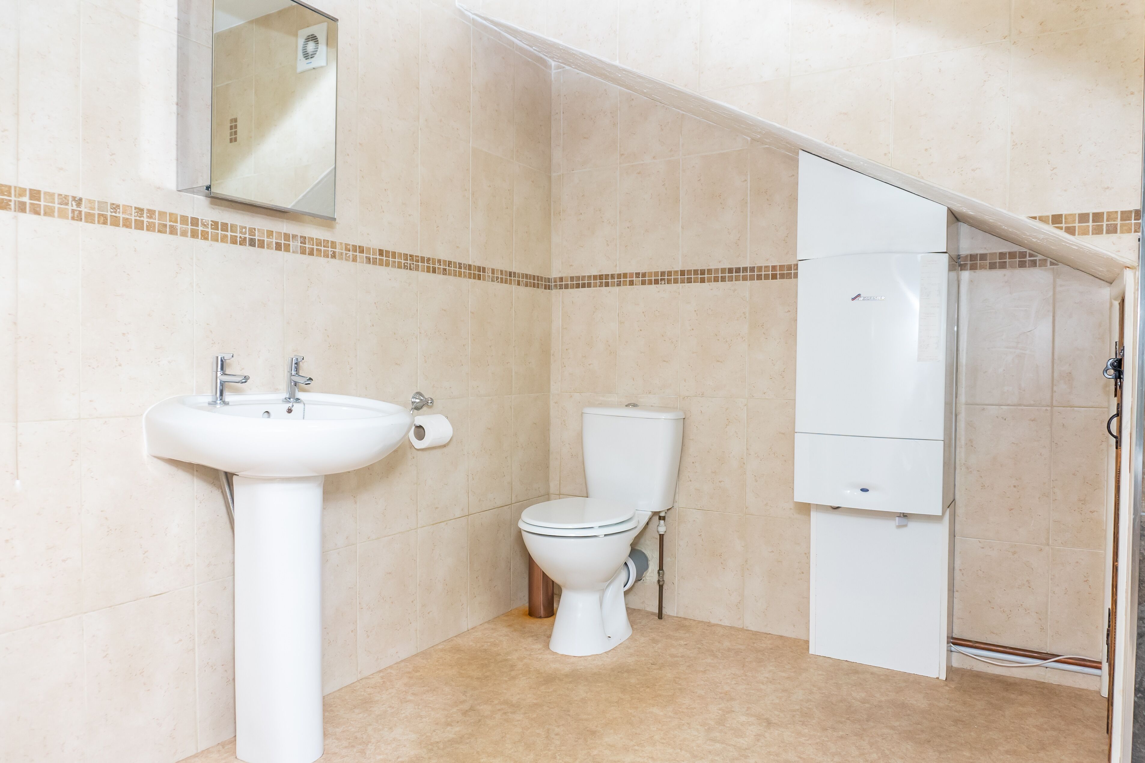A bathroom with a sink, toilet, and a cabinet.