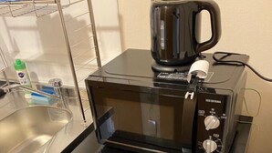 A compact kitchen with a microwave, a coffee maker, and a refrigerator. - Crystal Court (Miyakojima)