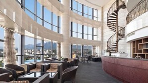 A spacious indoor area with high ceilings, large windows, and a central spiral staircase. - Ronzou International Hotel (Rong County)