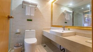 A modern bathroom with a toilet, sink, and mirror. - Vienna International Hotel Zhongshan Torch Zone (Zhongshan)