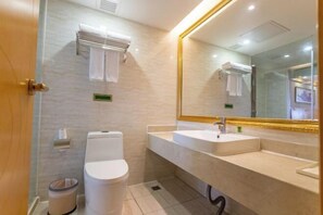 A modern bathroom with a toilet, sink, and mirror. - Vienna International Hotel Zhongshan Torch Zone (Zhongshan)