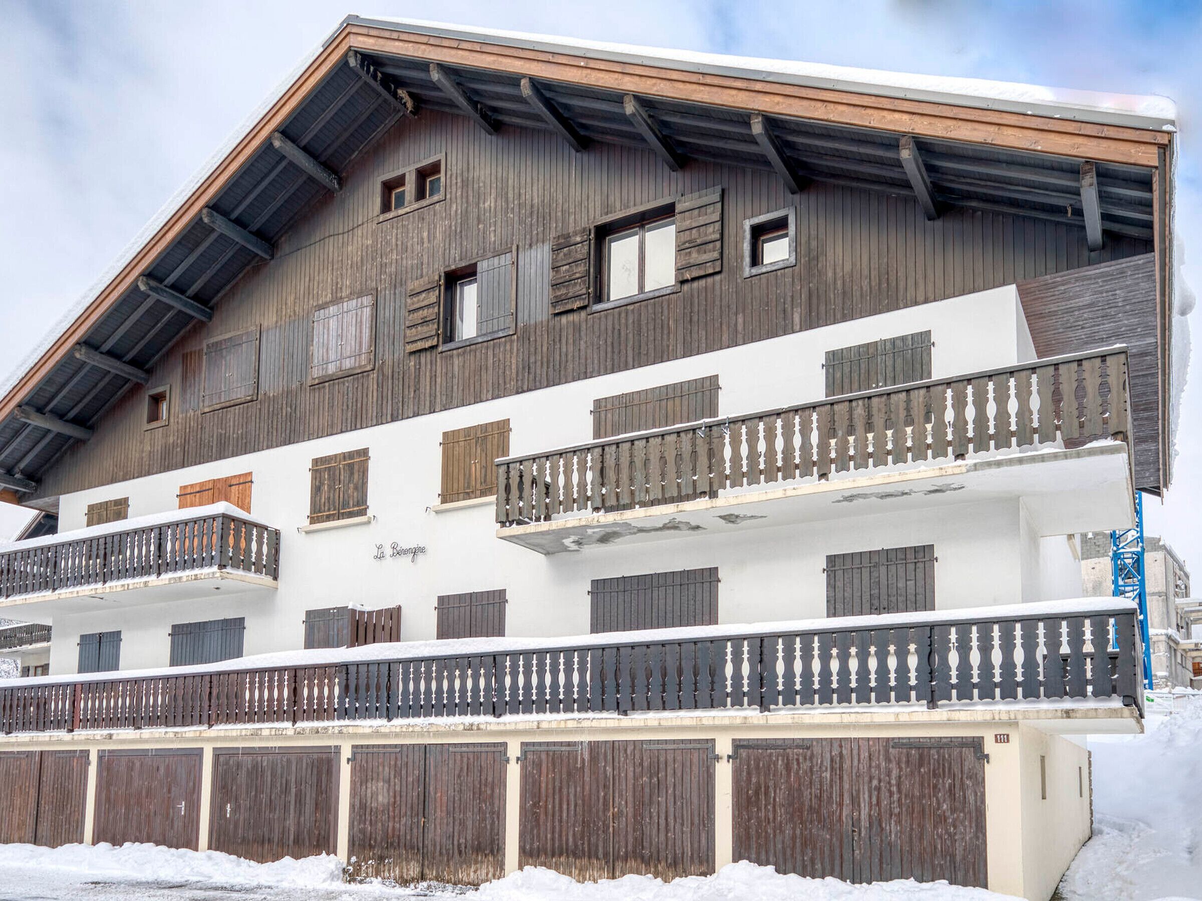 Un edificio de varios pisos con balcones de madera y un letrero que dice 'La Benne'.