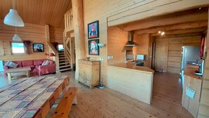 A cozy cabin interior with a wooden interior, a sofa, a dining table, and a kitchen area. - Spacious chalet 14 pers., fireplace, parking La Joue du Loup (La Joue du Loup)