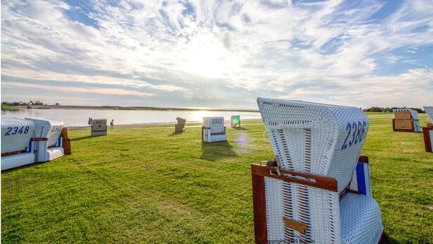 A grassy area with numbered tents and a chair, likely for an event or gathering. - Spacious vacation apartment in a central and quiet location with terrace (Büsum)
