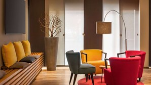 A modern living room with a sofa, chairs, a floor lamp, and a large vase with branches. - Amedia Siegen, Trademark Collection by Wyndham (Siegen)