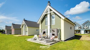 Una casa moderna con un patio, una mesa de comedor y asientos exteriores.