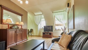 A living room with a sofa, a coffee table, a TV, and a cabinet. - Apartamenty Swinoujscie - Villa Teresa (Swinoujscie)