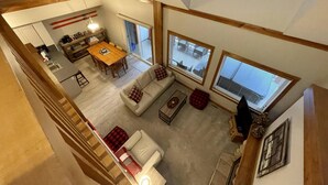 A spacious living area with a dining table, sofas, and large windows. - Alpine Bliss Awaits: Beautiful Mountain Home with Hot Tub (Kimberley)