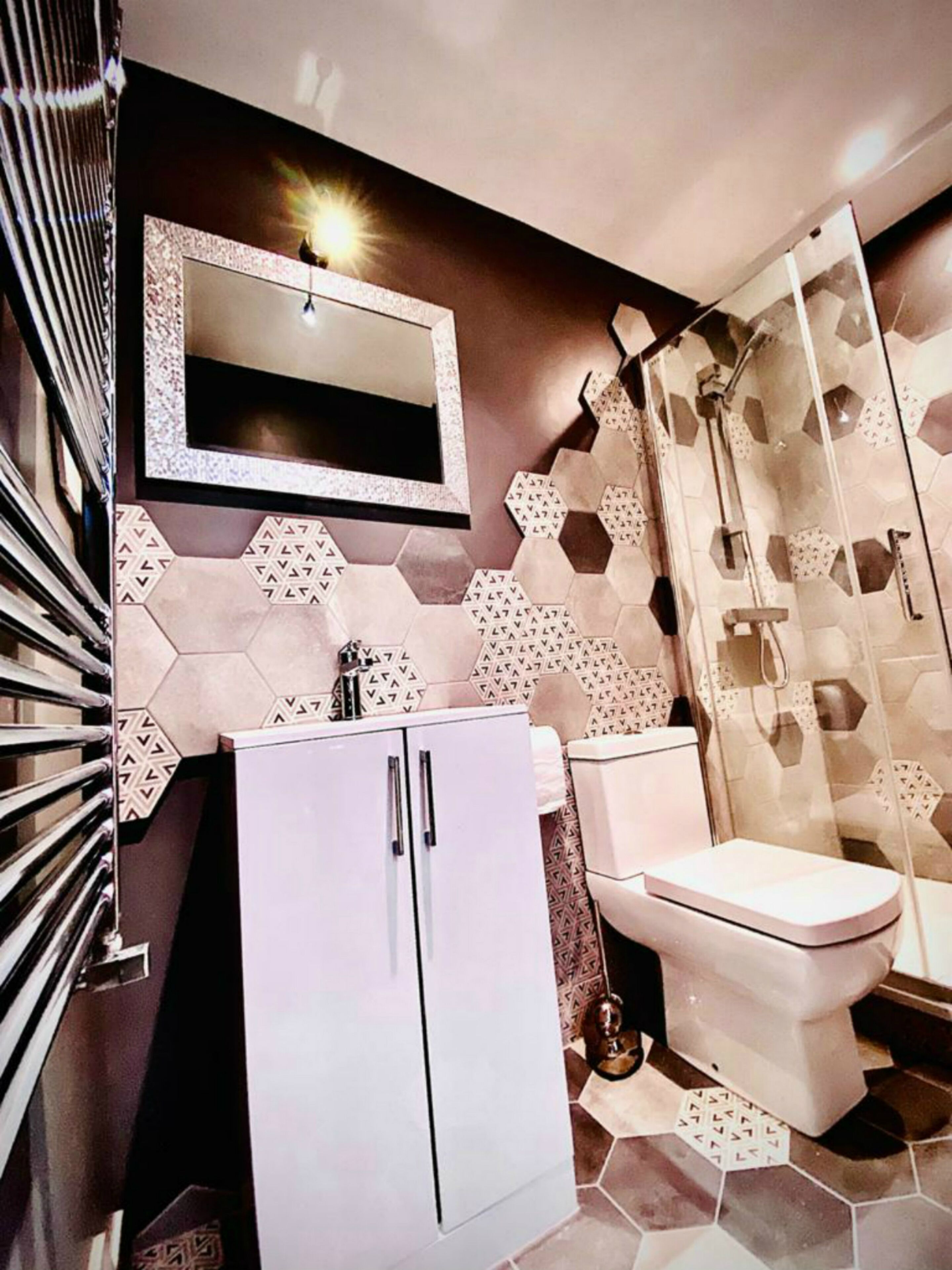 A bathroom with a shower, toilet, and cabinet.