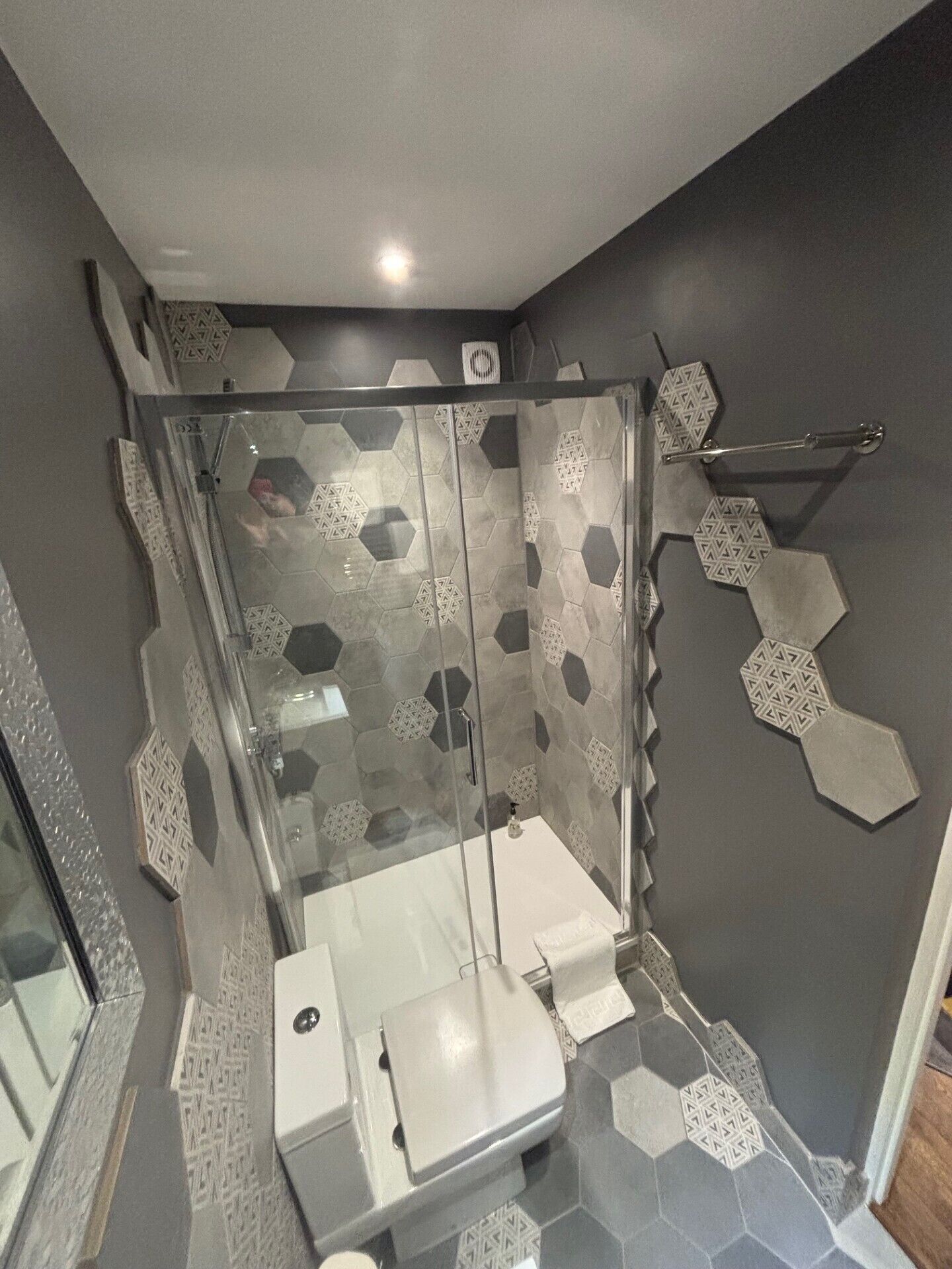 Ein modernes Badezimmer mit einer Duschkabine, einer Toilette und einem Waschbecken.