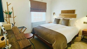 Ein Schlafzimmer mit einem hölzernen Bett, einem Schreibtisch, einer Heizung und einem Fenster mit Jalousie.