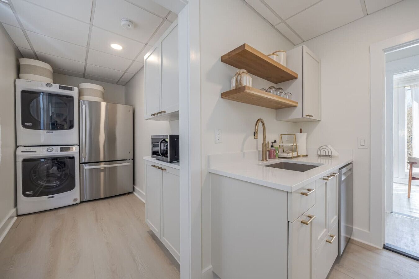 A compact kitchen with built-in appliances, a sink, and a window.