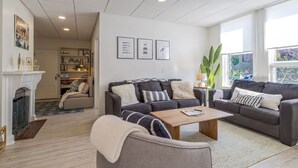 A modern living room with two sofas, a coffee table, and a fireplace. - Condo in the heart of town. (Bar Harbor)