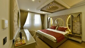 A hotel room with a large bed, a desk with a chair, a mirror, and a decorative ceiling. - G-Han Hotel (Istanbul)