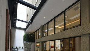A modern indoor dining area with multiple tables and chairs, large windows, and a high ceiling. - G-Han Hotel (Istanbul)