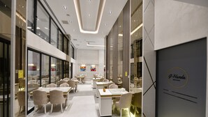 A modern restaurant interior with glass partitions, white tables, and chairs. - G-Han Hotel (Istanbul)