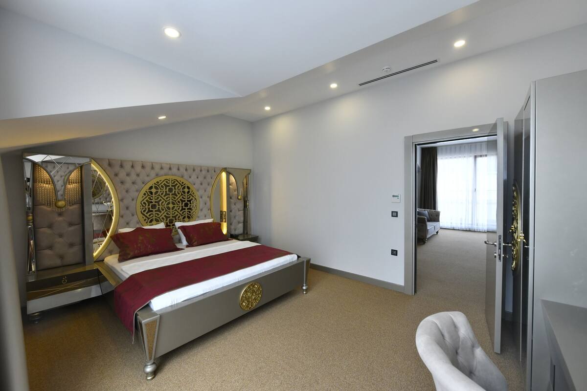 Een moderne slaapkamer met een groot bed, een kaptafel met spiegel en een inloopkast.