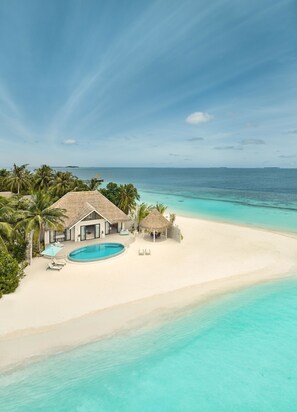 A beachfront property with a swimming pool, thatched-roof structures, and a sandy beach. - Nova Maldives (Vakaru)