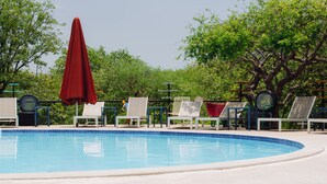 Una piscina con sillas de descanso y sombrillas.