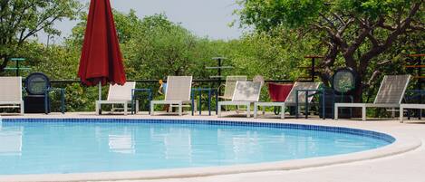 Una piscina con sillas de descanso y sombrillas.
