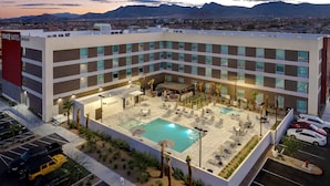 A hotel with a rooftop pool, multiple floors, and a view of mountains. - Home2 Suites by Hilton Las Vegas Northwest (Las Vegas)