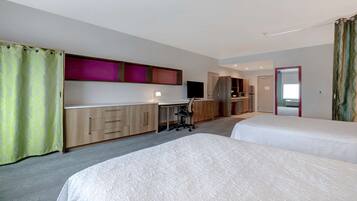 A hotel room with two beds, a desk, a chair, a TV, and a wardrobe.